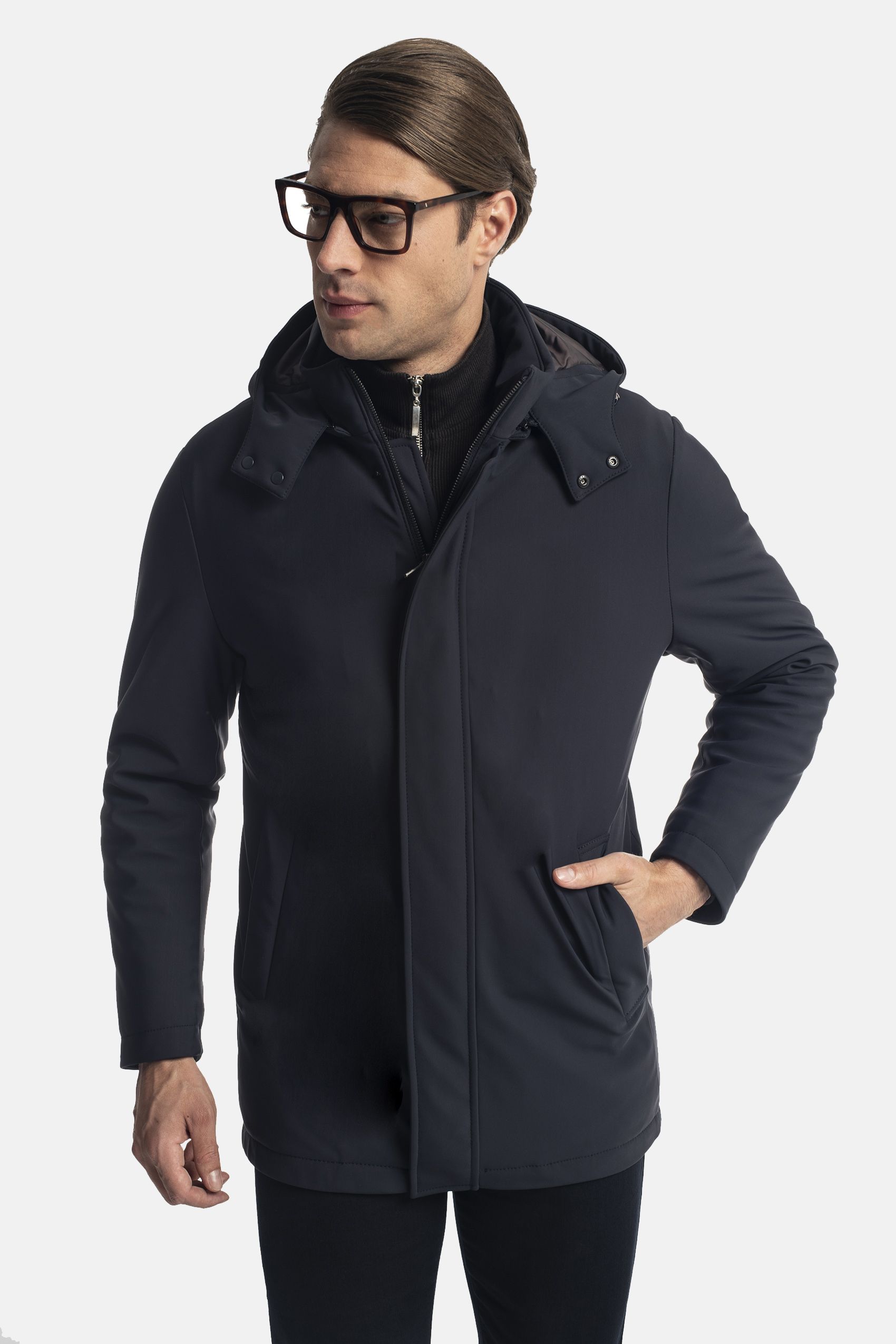 Mężczyzna ubrany w ciemną kurtkę z kapturem i czarne spodnie