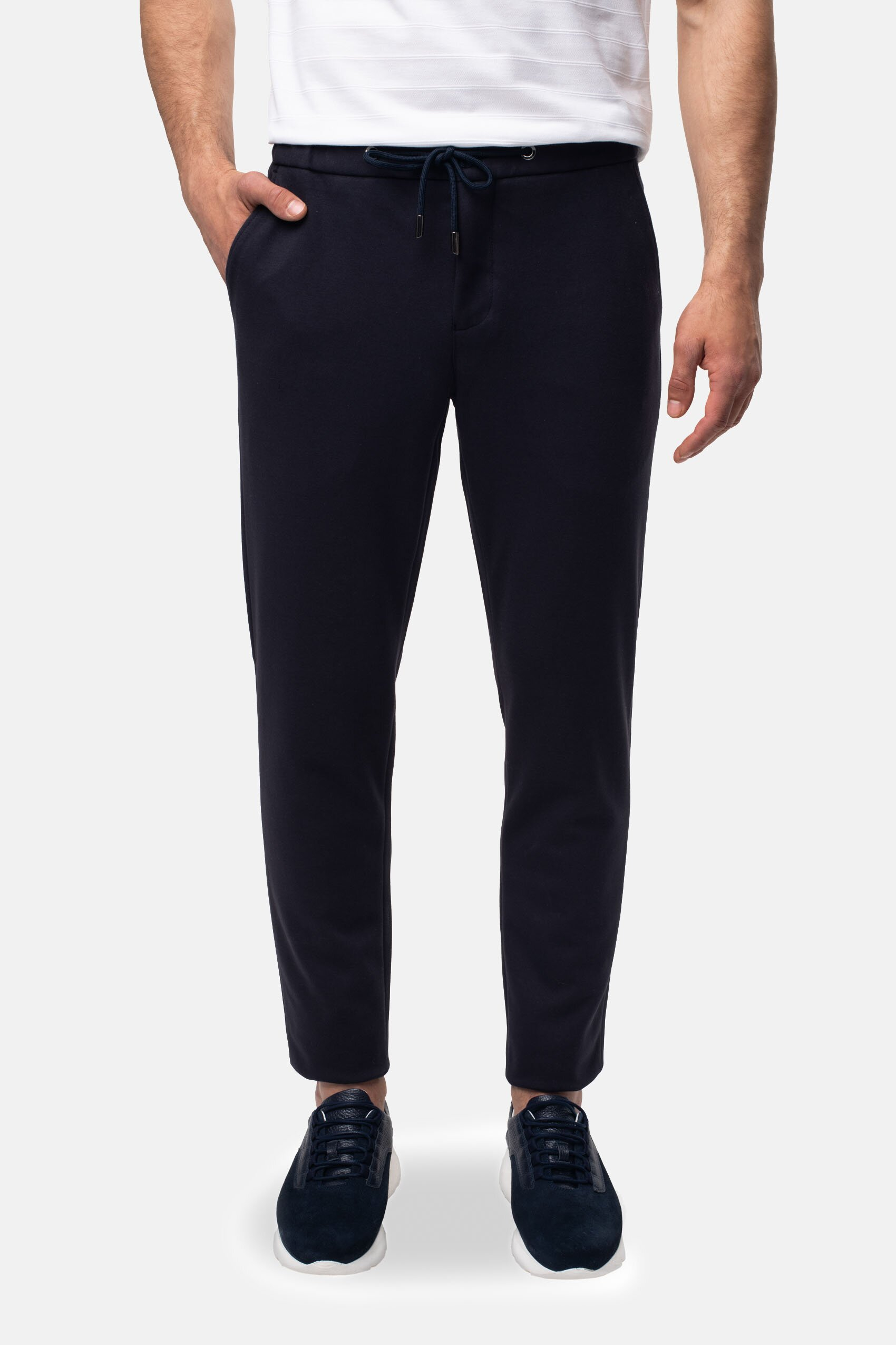 Model ubrany w joggery czarne, białą koszulkę i sportowe buty