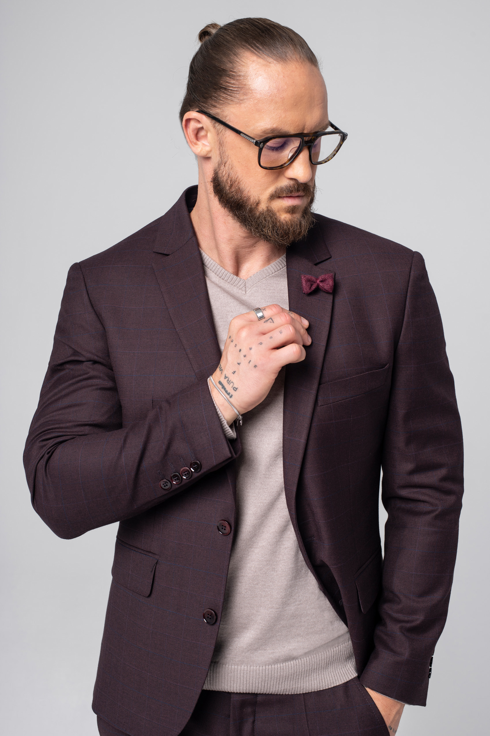 Mężczyzna ubrany w bordową marynarkę i beżowy sweter